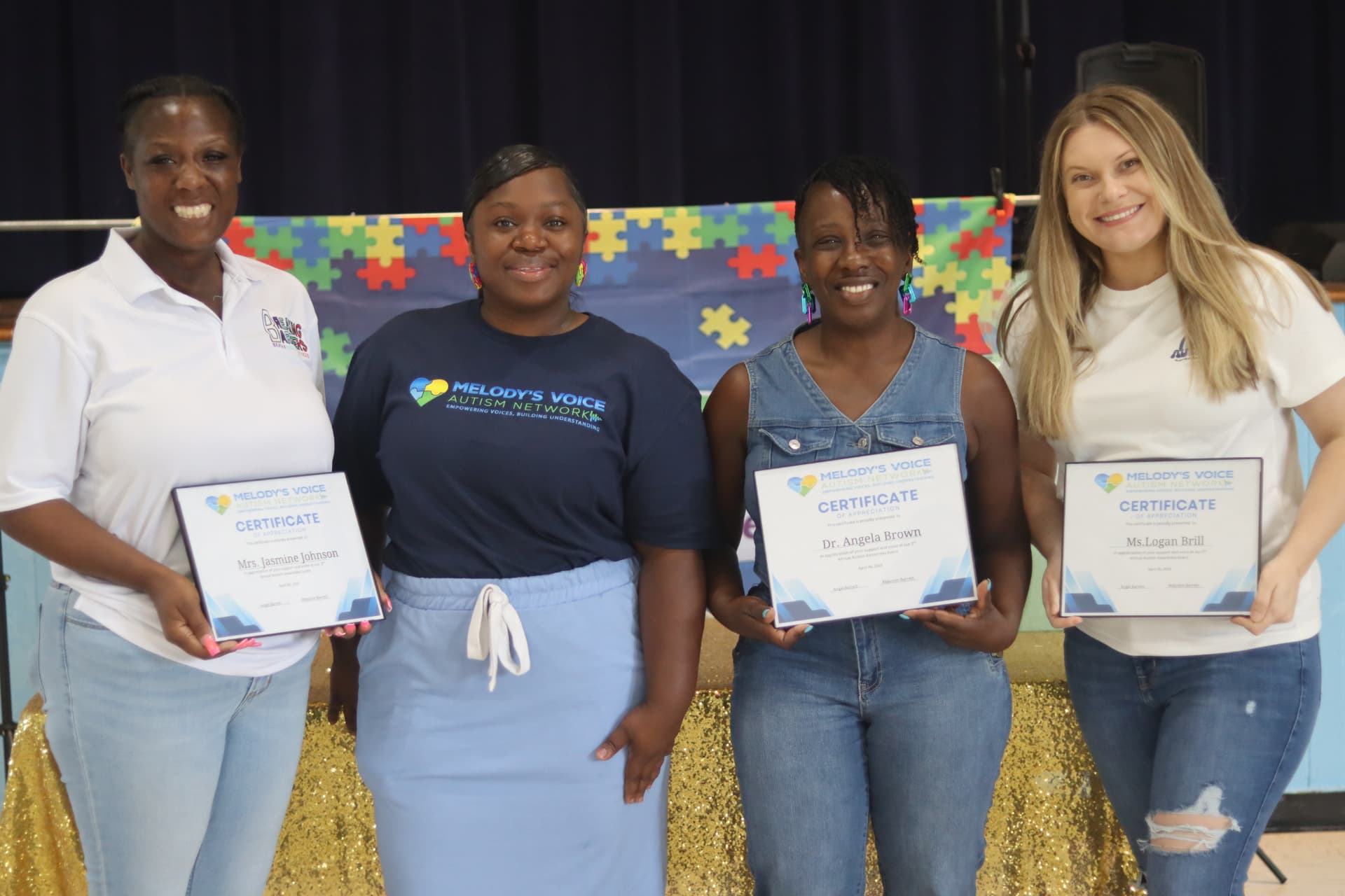 Melody's Voice team members and community partners holding certificates of appreciation at an event