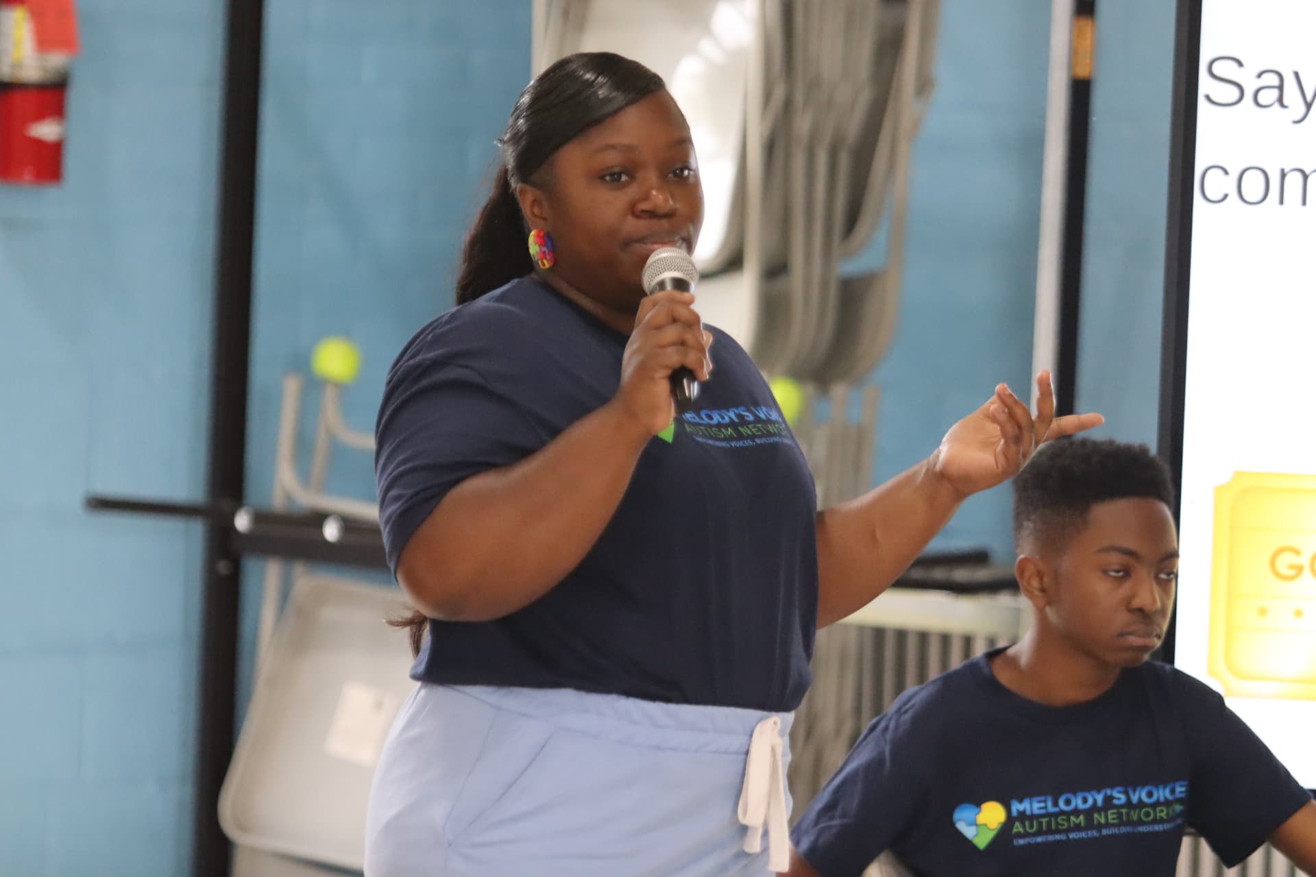 A Melody's Voice speaker addressing families at an Autism Awareness event